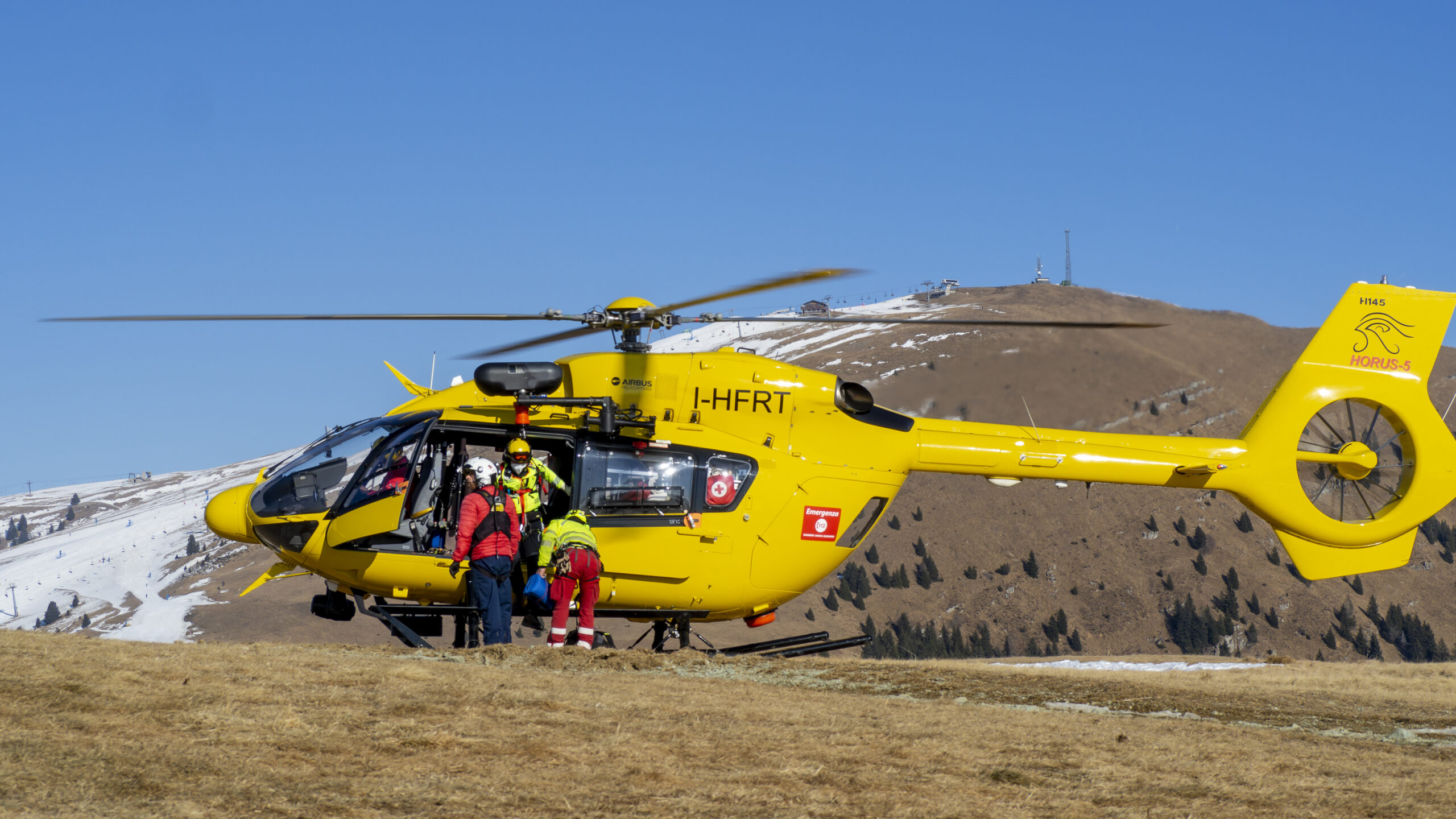 Rescue helicopter over the mountains to help hikers. First aid helicopter. Team ready for emergency response. Medical rescue helicopter on the ground